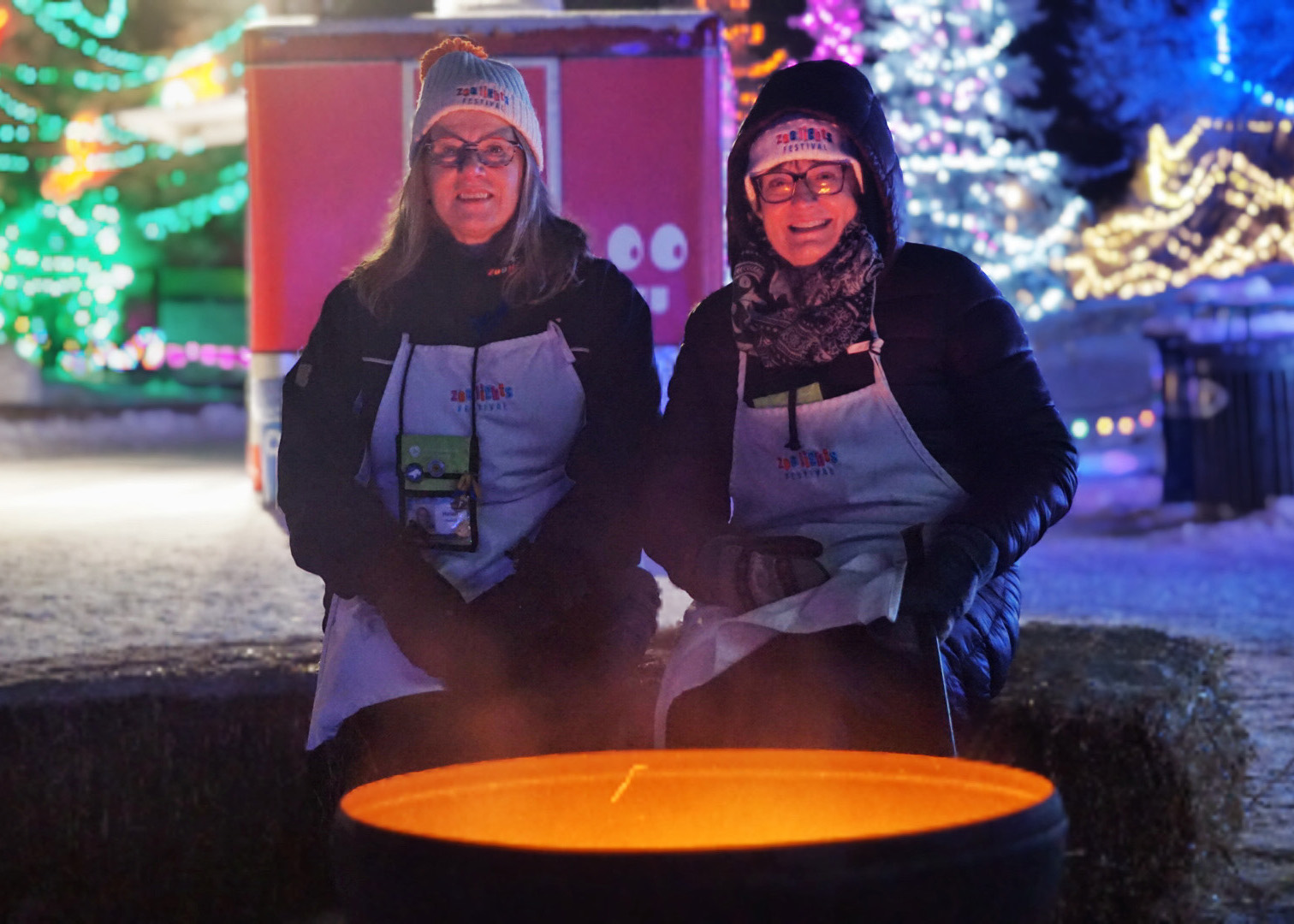 Two volunteer sit around a warm fire pit